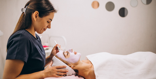 Esthéticienne-chapo.jpeg (Cosmetologist applying mask on a face of client in a beauty salon)