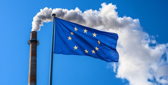 Aides FSE - chapo.jpeg (European Union Flag Fluttering in the Wind Against a Background of Industrial Smokestack Emissions.)
